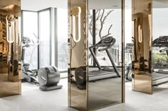 an exercise room with mirrors and treadmills