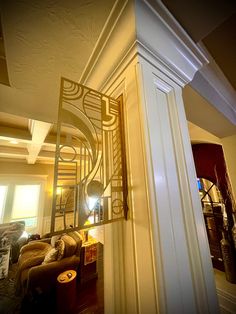 a living room filled with furniture and a tall white pillar in the middle of it