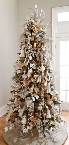 a white christmas tree with gold and silver decorations