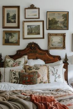 a bed with lots of pillows and pictures on the wall above it's headboard