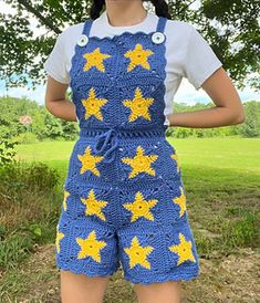 a woman wearing blue and yellow crocheted overalls with stars on the side