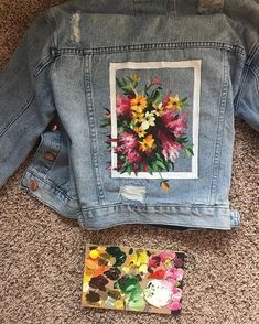 the back of a jean jacket with flowers on it, and an instagram sticker