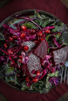 a salad with pomegranate, lettuce and cranberries