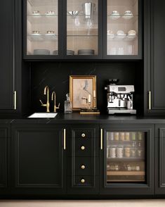 a kitchen with black cabinets and gold trim on the glass doors, white plates and silverware