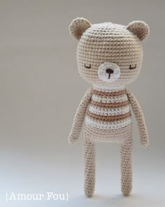 a crocheted teddy bear with eyes closed