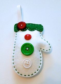 a white felt ornament with green and red buttons on it's side