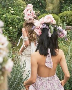 two girls in flower crowns walking through the garden