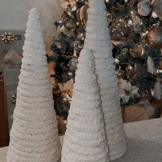 two white christmas trees sitting on top of a table