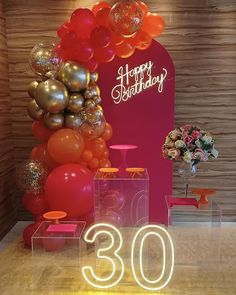 the 30th birthday sign is displayed with balloons and flowers in front of an illuminated display