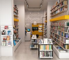 the inside of a book store with many books on shelves and various tables in front of them