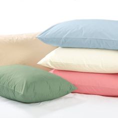 four pillows stacked on top of each other with the same color pillow in front of them