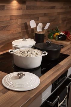 a kitchen counter with pots and pans sitting on top of it next to an oven