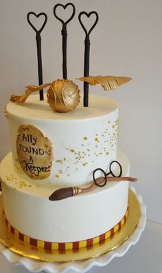 a white cake with gold decorations and scissors on top