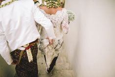 a man and woman dressed in traditional thai garb are walking down the stairs together