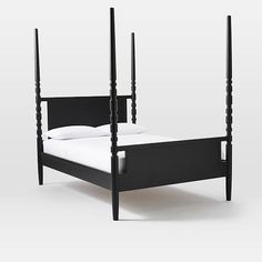 a bed with four posts and white sheets