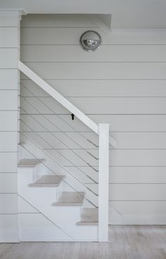 a white staircase in a house with wood floors