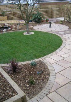 a backyard with grass and stone walkways