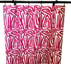 a red and white shower curtain hanging from a metal rod with the word'love'painted on it