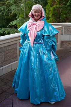 an older woman in a blue dress and pink scarf