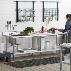 a man standing in front of a kitchen sink filled with lots of vegetables and cooking utensils