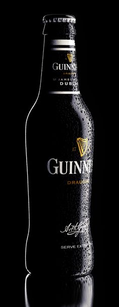 a bottle of guinness on a black background