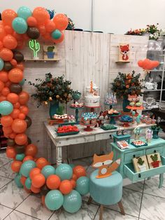 an orange and blue dessert table with balloons