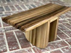 a wooden bench sitting on top of a brick floor