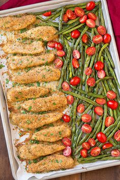 the recipe for breaded chicken served with green beans, tomatoes and cherry tomatoes is shown