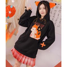 a woman wearing a black hoodie with an orange fox on it