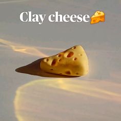 a piece of cheese floating in the air with text clay cheese on it's side