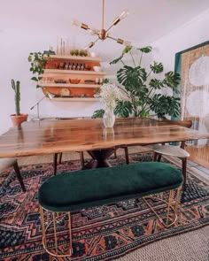 a dining room table with a bench and potted plants