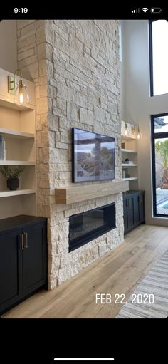 a living room with a large stone fireplace