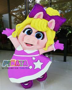 the mascot is dressed in pink and purple with stars on it's chest, holding her arms up