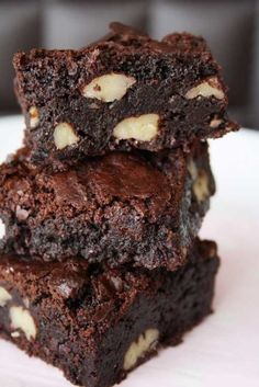 three brownies stacked on top of each other with white chocolate chips and almonds