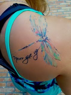 the back of a woman's shoulder with a tattoo saying, never give up