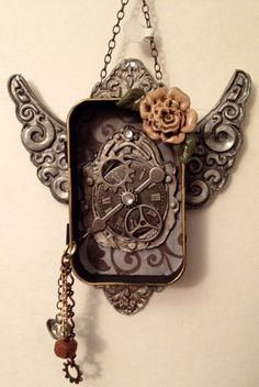 an ornate clock with angel wings and a flower hanging from it's back side