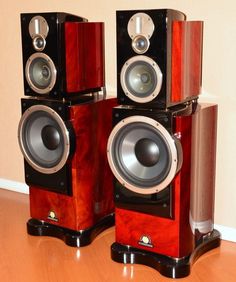 two speakers sitting on top of a wooden floor