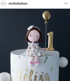 a birthday cake with a girl holding a balloon and the number one on it's side