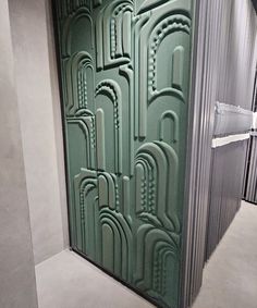 an art piece made out of green glass in a room with concrete floors and walls