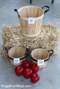 three buckets with numbers on them sitting next to straw bales and tomatoes in the middle