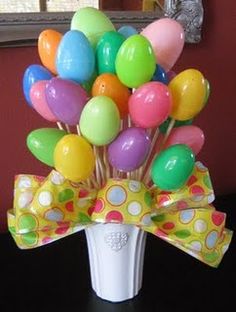 a bunch of balloons in a vase with toothbrushes on the top and bottom