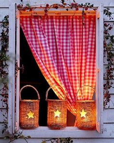 two wicker baskets sit in front of a window with red and white checkered curtains