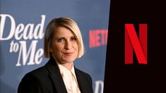 a woman in a suit and tie standing next to a dead to me netflix logo