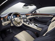 the interior of a car with black leather and tan trim