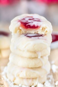 a stack of cookies with jelly on top and white sugar in the middle, sitting on a table