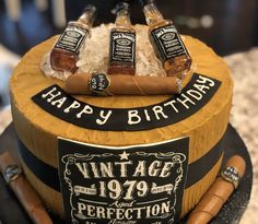 a birthday cake with whiskey bottles and cigars on it