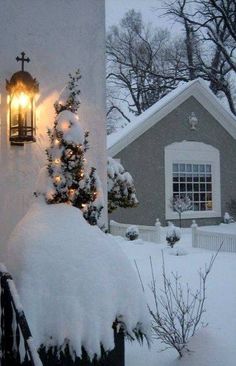 a house covered in snow with a light on it