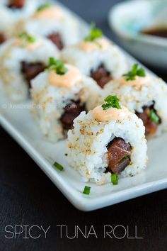 sushi rolls on a white plate with sauce and garnish