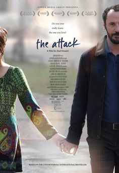 a man and woman holding hands in front of a poster for the movie, the attack