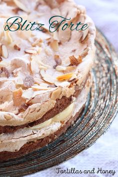 a close up of a cake with frosting and toppings on a glass plate